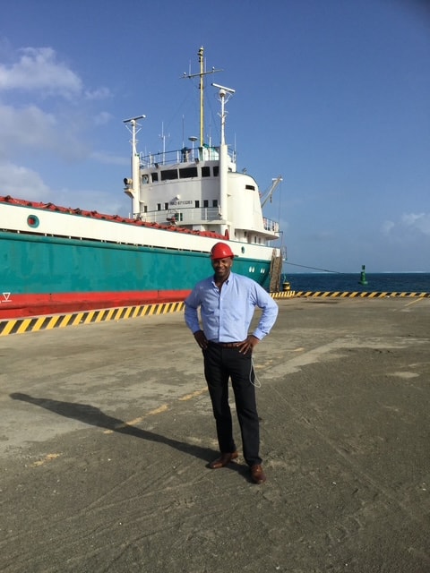 Founder standing dockside next to MV Anjelica Express